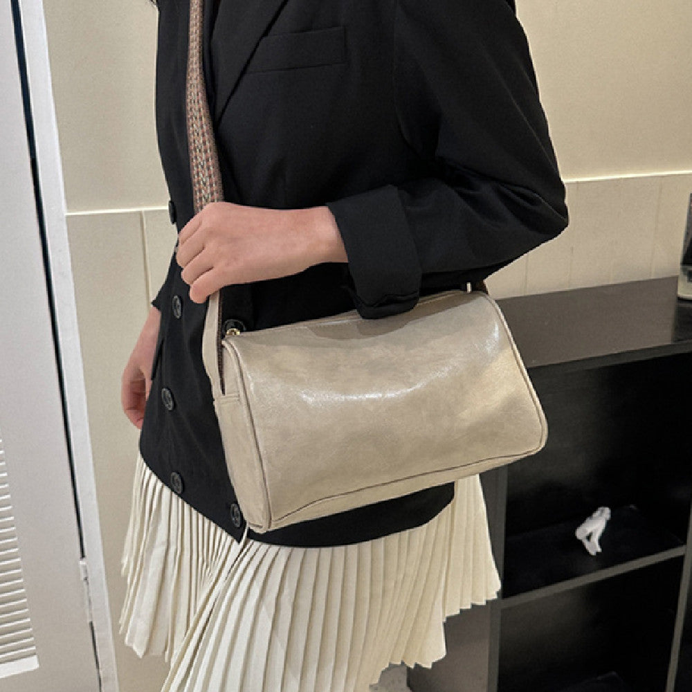 A model carrying a small, retro-inspired shoulder tote bag. The bag is perfect for everyday essentials and adds a touch of vintage charm to any outfit.