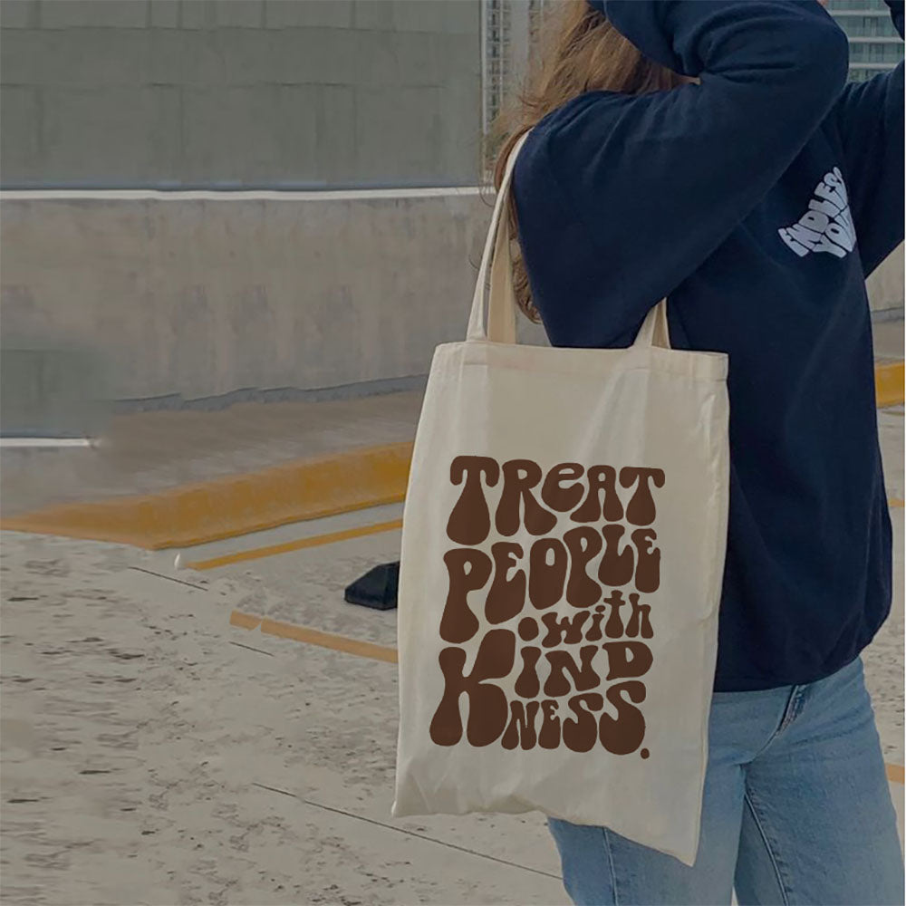A model showcasing a large, eco-friendly tote bag with an artistic design. The bag features a comfortable shoulder strap and a spacious interior, making it perfect for carrying everyday essentials while embracing sustainable style.