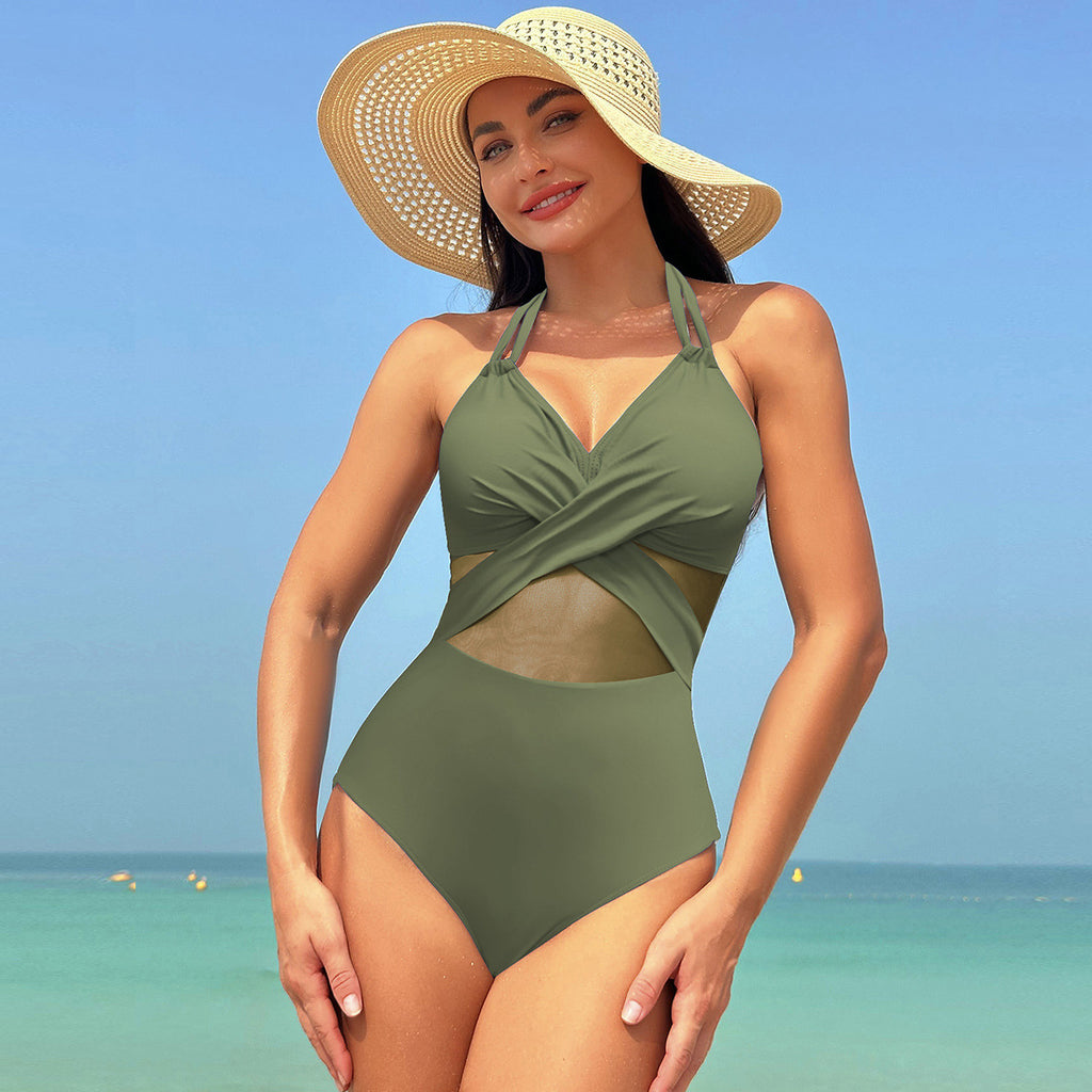  Halter-neck one-piece swimsuit in solid color with mesh detailing. Cross-strap back design. Nylon, spandex, and polyester blend fabric