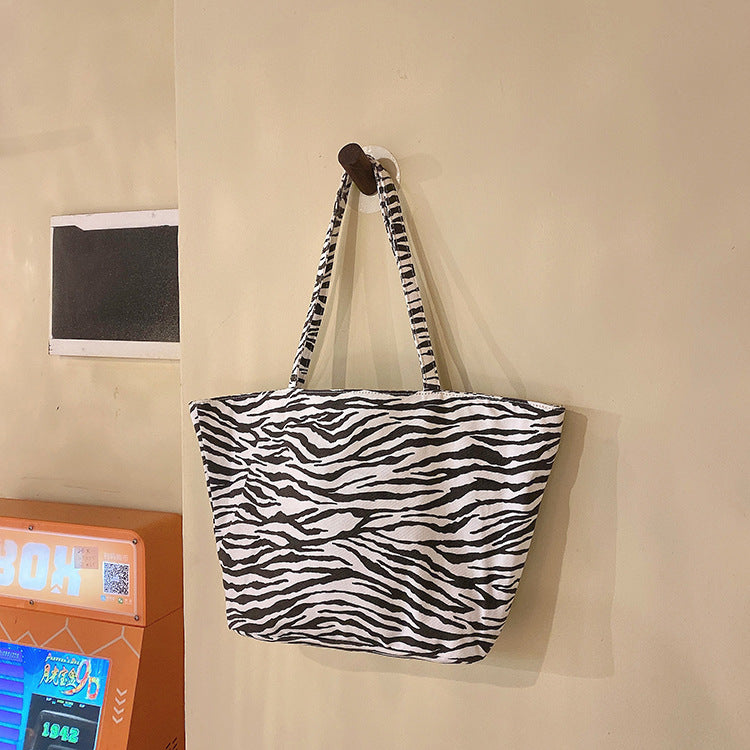 A collection of zebra-striped tote bags in various sizes. These stylish and versatile bags are perfect for everyday use, carrying groceries, beach essentials, or other belongings. They come in a bold black and white zebra print design and are available in different sizes to suit your needs.